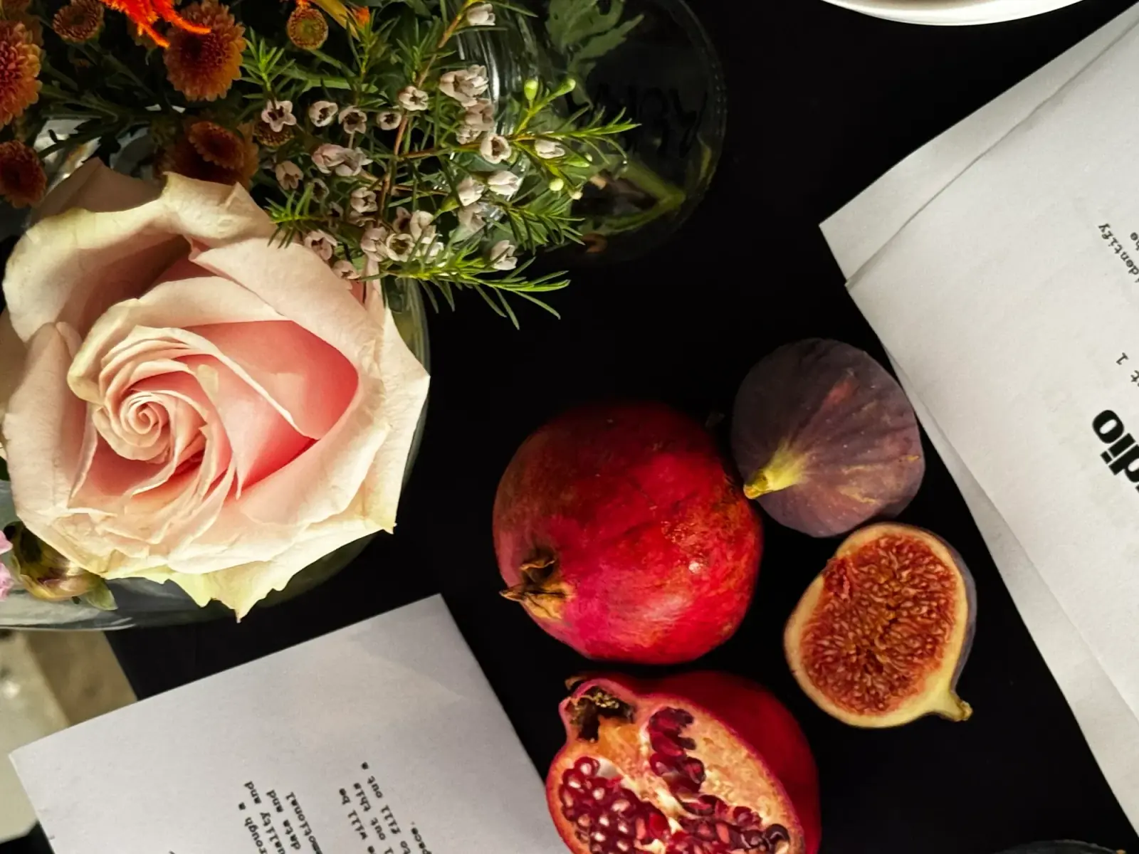 Pomegranate, figs and a pink rose on an Aura event table